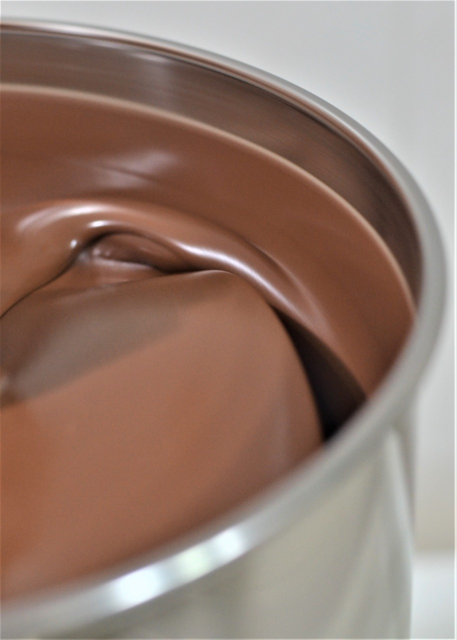 Chocolate sendo refinado no melanger, em processo artesanal